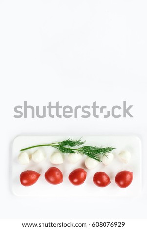 Top view of a fresh contrasting picture of a duet of small tomatoes and expensive cheese isolated in white, copy space. Healthy foods, cooking and vegetarian concept summer vegetables border.