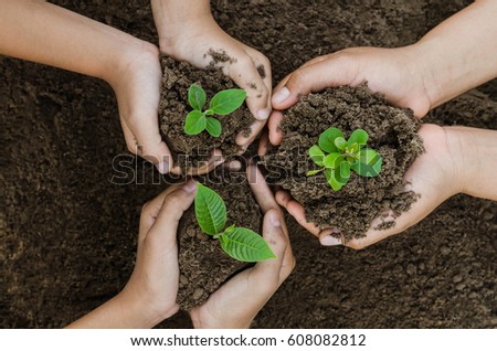 Growing concept eco Group hand  children planting together on soil background Royalty-Free Stock Photo #608082812