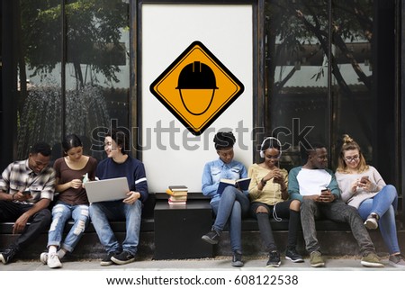 Group of Friends Sitting Together with Safety Helmet Attention Banner Behind