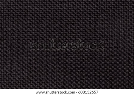 Black background with braided checkered pattern, closeup. Texture of the weaving fabric, macro.