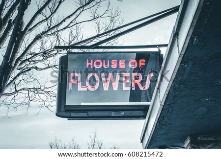 Street sign isolated. Entrance to garden. House of Flowers signage. Urban street photography retail store signage. Abstract street art and design. Building exterior.