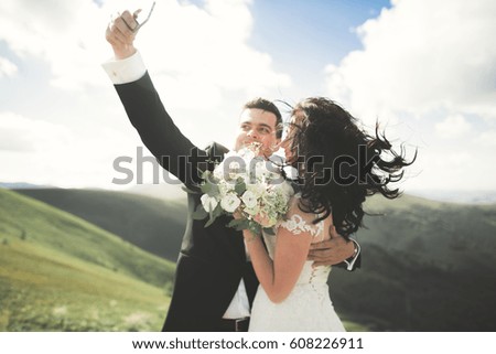 Just married couple on top of the mountain taking selfie picture