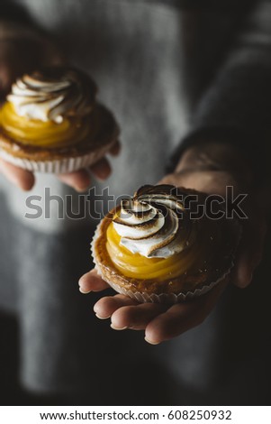 Lemon pie in woman hands. Traditional french sweet pastry tart. Delicious, appetizing, homemade dessert with lemon cream. Copy space, closeup. Selective focus. Toned