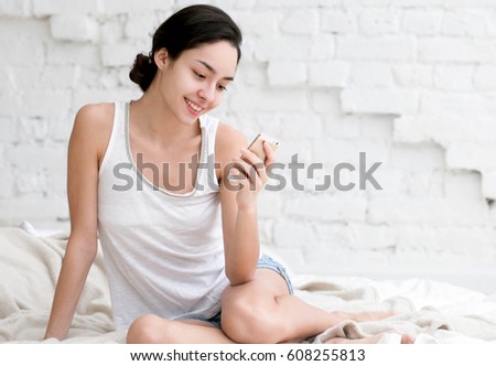 Young woman with mobile phone home.