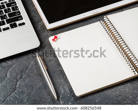 Laptop, pen and notebook with a spring on a black background. Clean page. Place for the text.