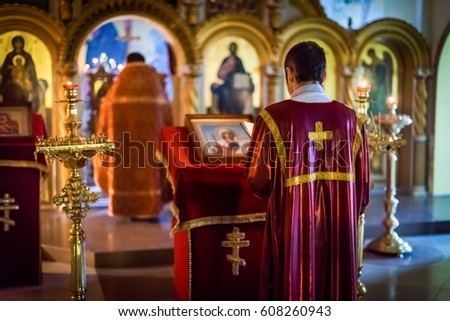 the priest standing with his back to the altar in the temple Orthodox Church Royalty-Free Stock Photo #608260943