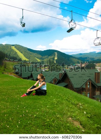 a young girl has a rest in the mountains in the grass