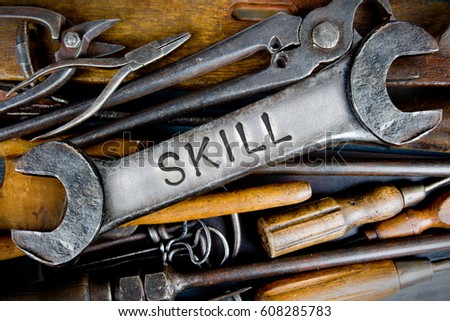 Photo of various tools and instruments with SKILL letters imprinted on a clear wrench surface