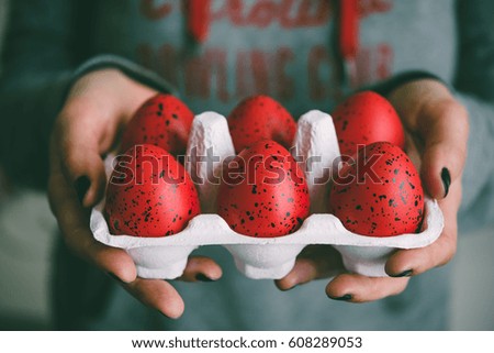 Hands holding modern painted easter eggs. Toned picture