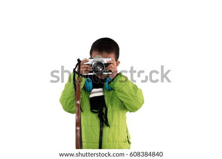 Cute little boy in sweater green holding film camera on white background.