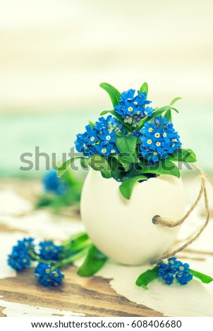 Forget me not flowers in egg shell. Easter decoration. Vintage style toned picture