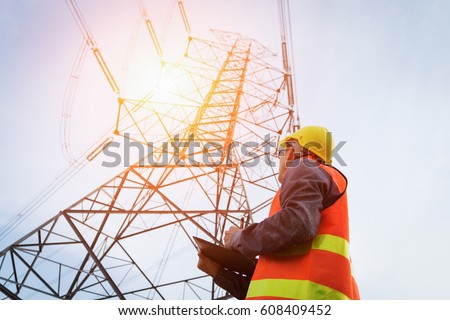Engineering working on High-voltage tower, Check the information on paper. Royalty-Free Stock Photo #608409452