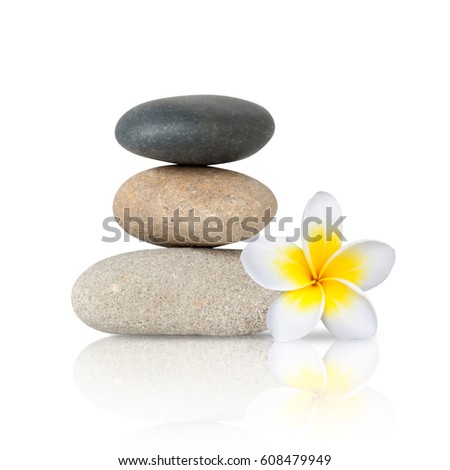 Zen spa concept on white background -  stack of stones with frangipani plumeria flower 