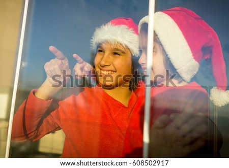 Two cute boys brothers on window waiting for Santa and New Year