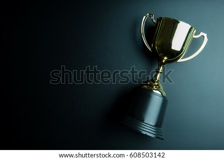 Golden trophy isolated on black background with copy space.Concept winner Royalty-Free Stock Photo #608503142