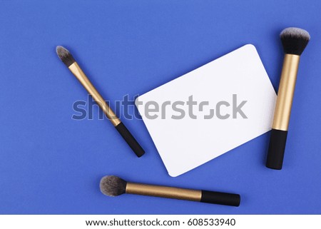 Beauty background. Make up brushes and white blank card. Top view. Flat lay.