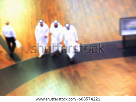 Arab sheikhs man in a mall make a purchase, Dubai, people go to the mall, market, blurred for backgroundd Royalty-Free Stock Photo #608574221