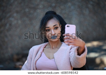 Beautiful woman wearing pink casual clothes taking selfie. Horizontal outdoors shot.