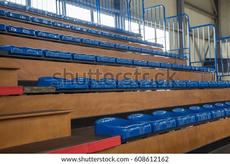 Row of blue partially numbered stadium seats. Watch a game