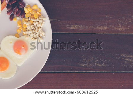 fried eggs in the shape of heart  , corn, red bean, pivot / Healthy breakfast concept / soft focus picture / Vintage concept
