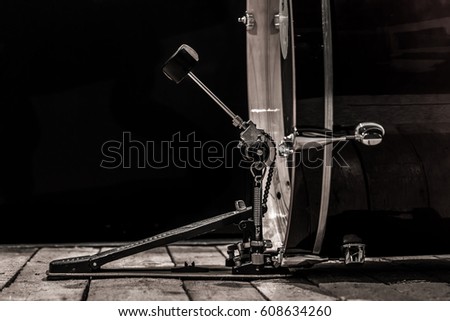 percussion instrument, bass drum with pedal on wooden boards with a black background, the music concept