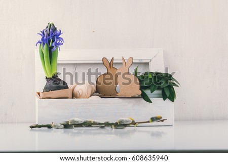 Easter decoration with wooden eggs, rabbits and flowers in box