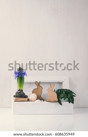 Easter decoration with wooden eggs, rabbits and flowers in box