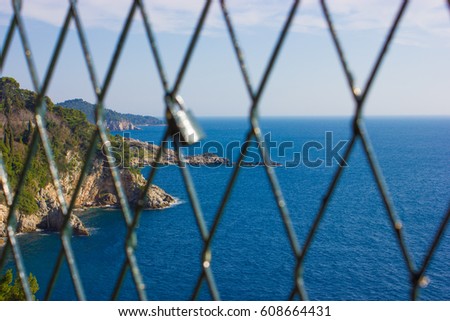 Love locks hanging on a lookout over blue ocean