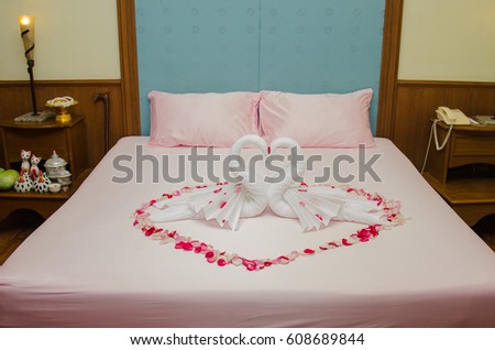 White two towel swans and red rose on the bed in Honey moon bed