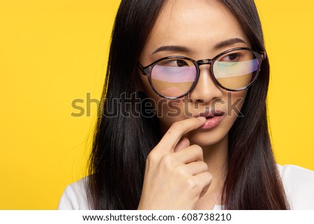 Portrait of a woman in beautiful glasses on a bright yellow background