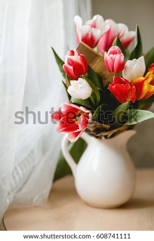 Tulips in a jar on a table
