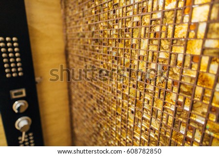 The texture of the small tile mosaic is brown with sparkles in the bathroom.