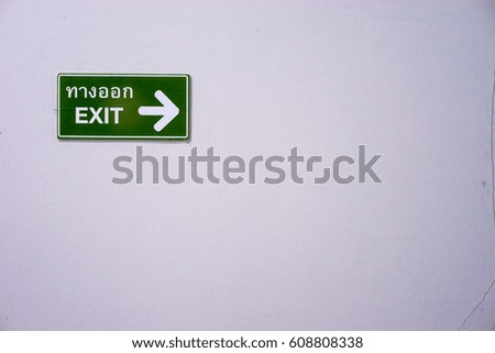 exit board on white wall with thai language.