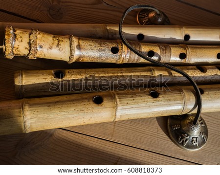 Bamboo Japanese flutes. Four Japanese flutes. Indian percussion musical instrument. Karataly with the inscription Om. Ethnic wind instrument. Screensaver for your desktop.