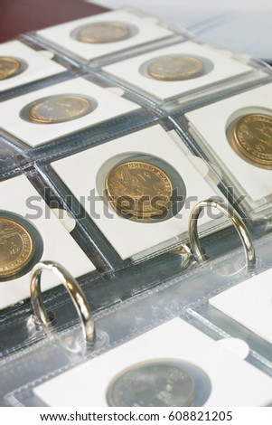 Coins in the album. Selective focus.