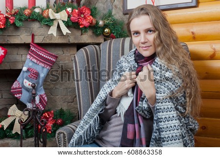 Young girl wrapped in plaid sitting in the chair