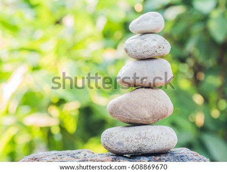 Pile of balancing pebble stones, like ZEN stone with burred nature background
