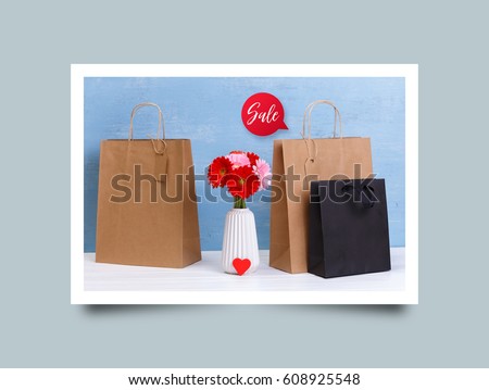 Mockup of blank shopping bags. Sale speech bubble. Gerbera flowers and red heart. Brown and black craft packages. Concept for sales or discounts. Blue wooden rustic board
