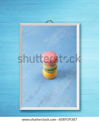 Macaroon cakes. Different types of macaron. Colorful almond cookies. On blue wooden rustic background. Photo frame on wooden rustic wall.