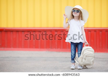 Pretty little girl in a striped dress and hat relaxing on the beach near sea, summer, vacation, travel concept. smiling cute little girl on beach vacation. 