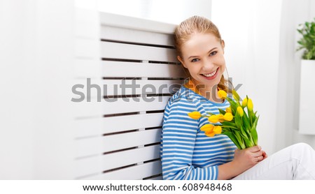 Happy woman with yellow flowers tulips
