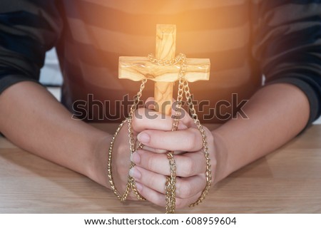 Woman hands holding wooden cross - religion concept