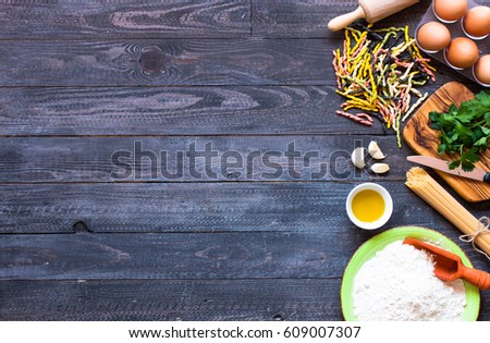Pasta background. Several types of pasta with vegetables, on a wooden table. Free space for text. Top view