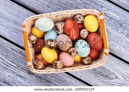 Top view of Easter basket. Colorful chicken and quail eggs. Easter picnic ideas.