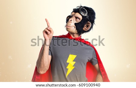 Superhero monkey man pointing up on ocher background