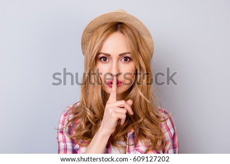 Keep silence! Portrait of young pretty woman holding her finger near lips and making silence gesture. Royalty-Free Stock Photo #609127202