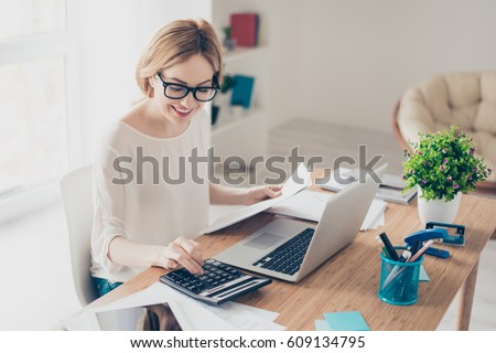 Happy cute  pretty accountant working with computer and calculator. Royalty-Free Stock Photo #609134795