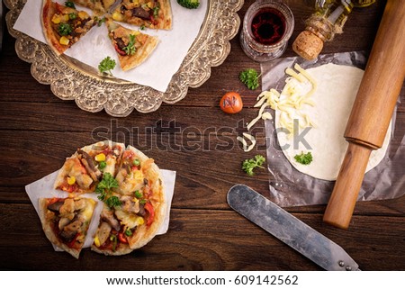 Pizza and red wine on wooden table background.