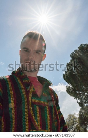 Young Man Looking at Camera With the Sunlight Shinning Overhead