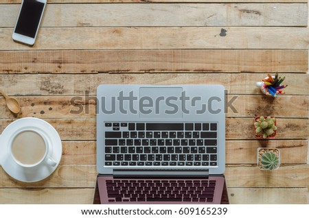 Office stuff and it gadgets display on top view business desk with copy space at text of picture. Creative table, modern project. Business empty laptop smartphone on wood background.